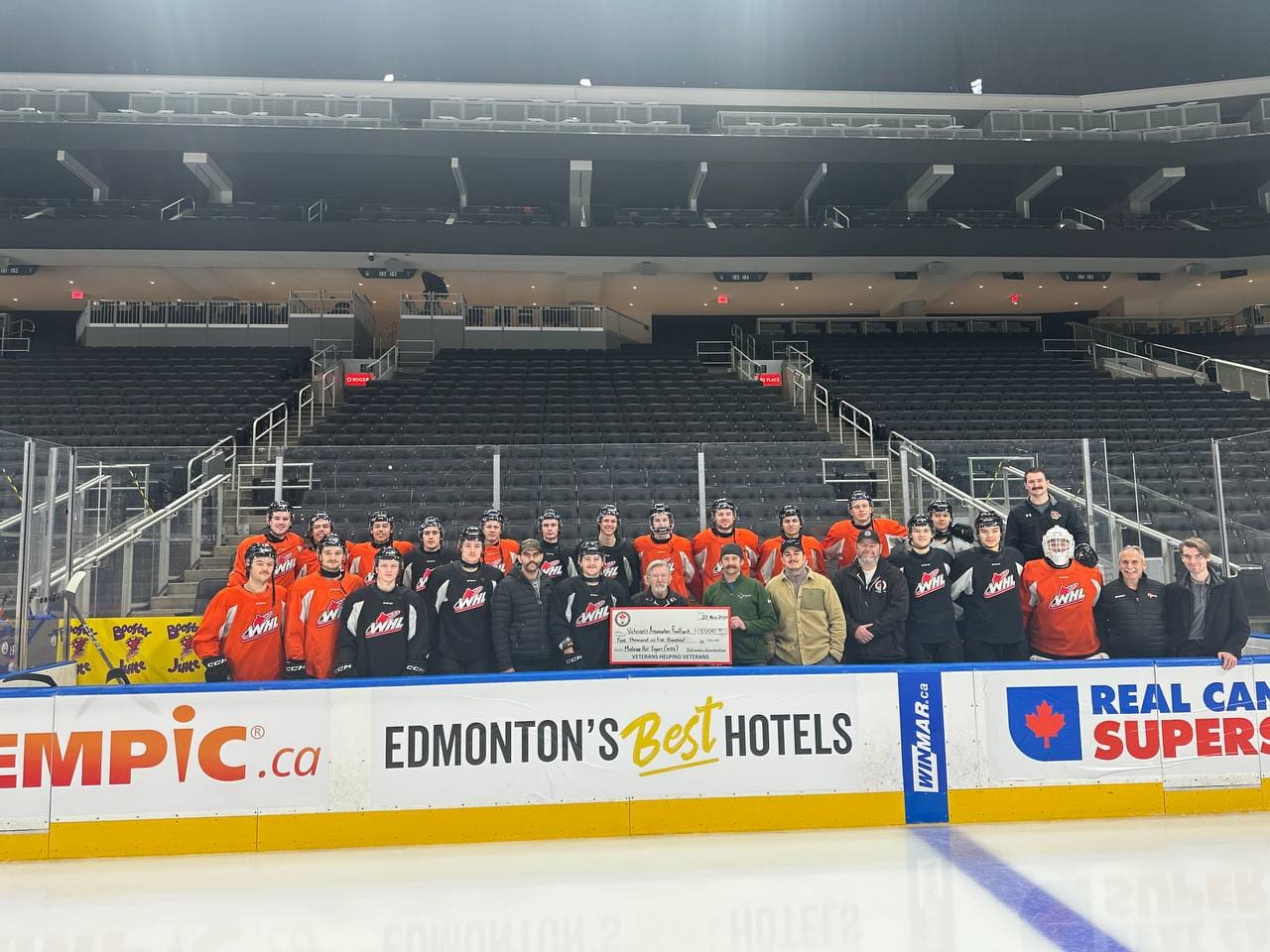Medicine Hat Tigers pose with a donation cheque after completing a leadership event with All Around Performance