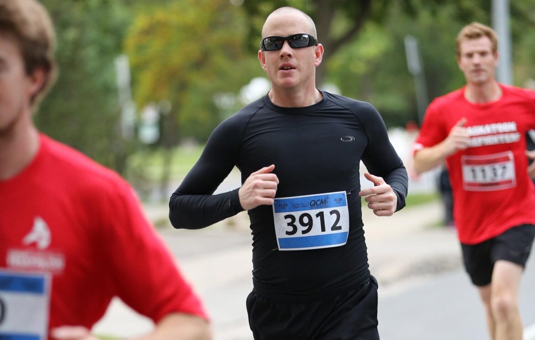 Marathon runner wearing race bib 3912 running in a road race, representing long-term goal setting and endurance.